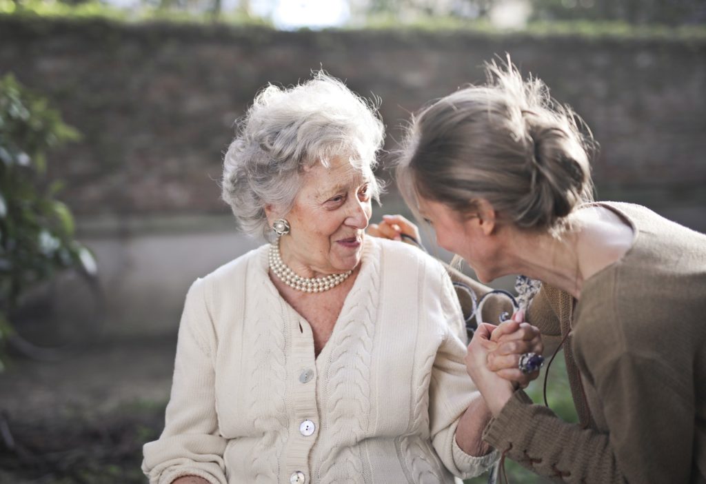 young woman and senior woman looking at each other smiling