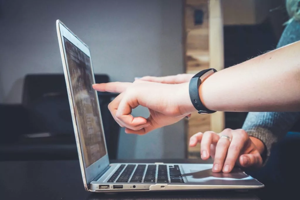 A person pointing out 2025 business trends on a laptop