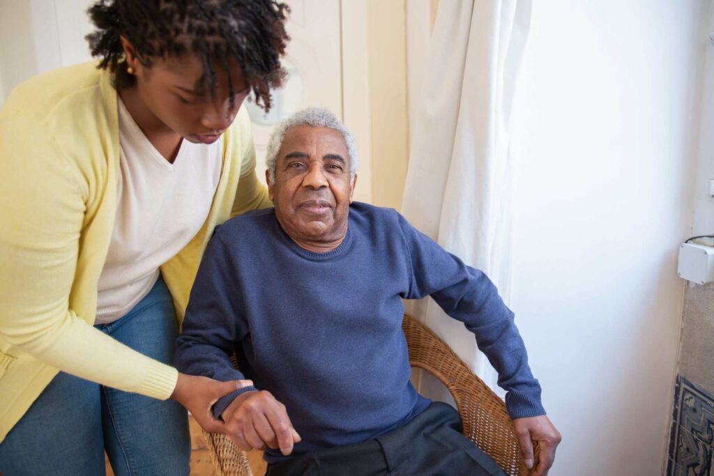 An in-home caregiver assists a senior