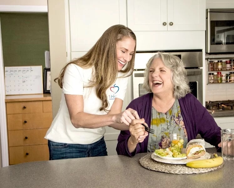 A home care franchise professional laughing with a senior citizen