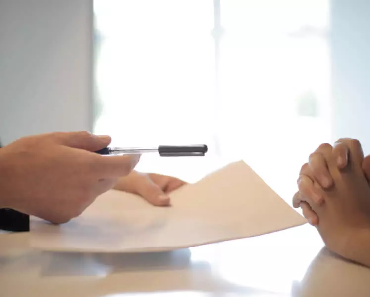 People signing paperwork.