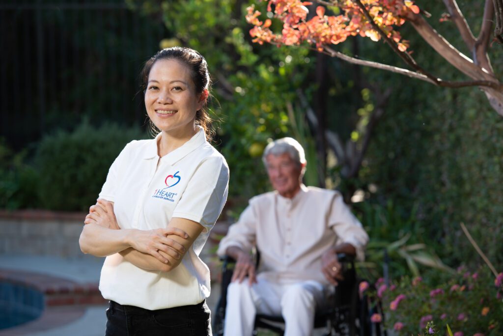 A caregiver smiling with their patient in the background