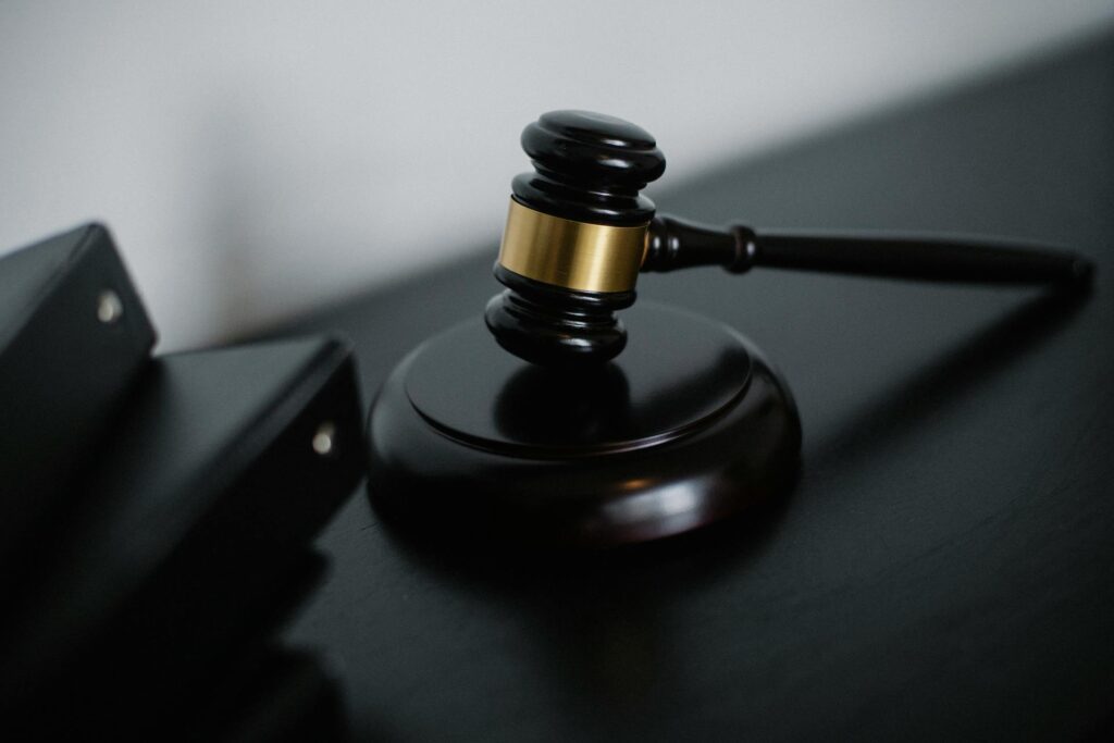 A black gavel near a stack of notebooks about franchise regulations